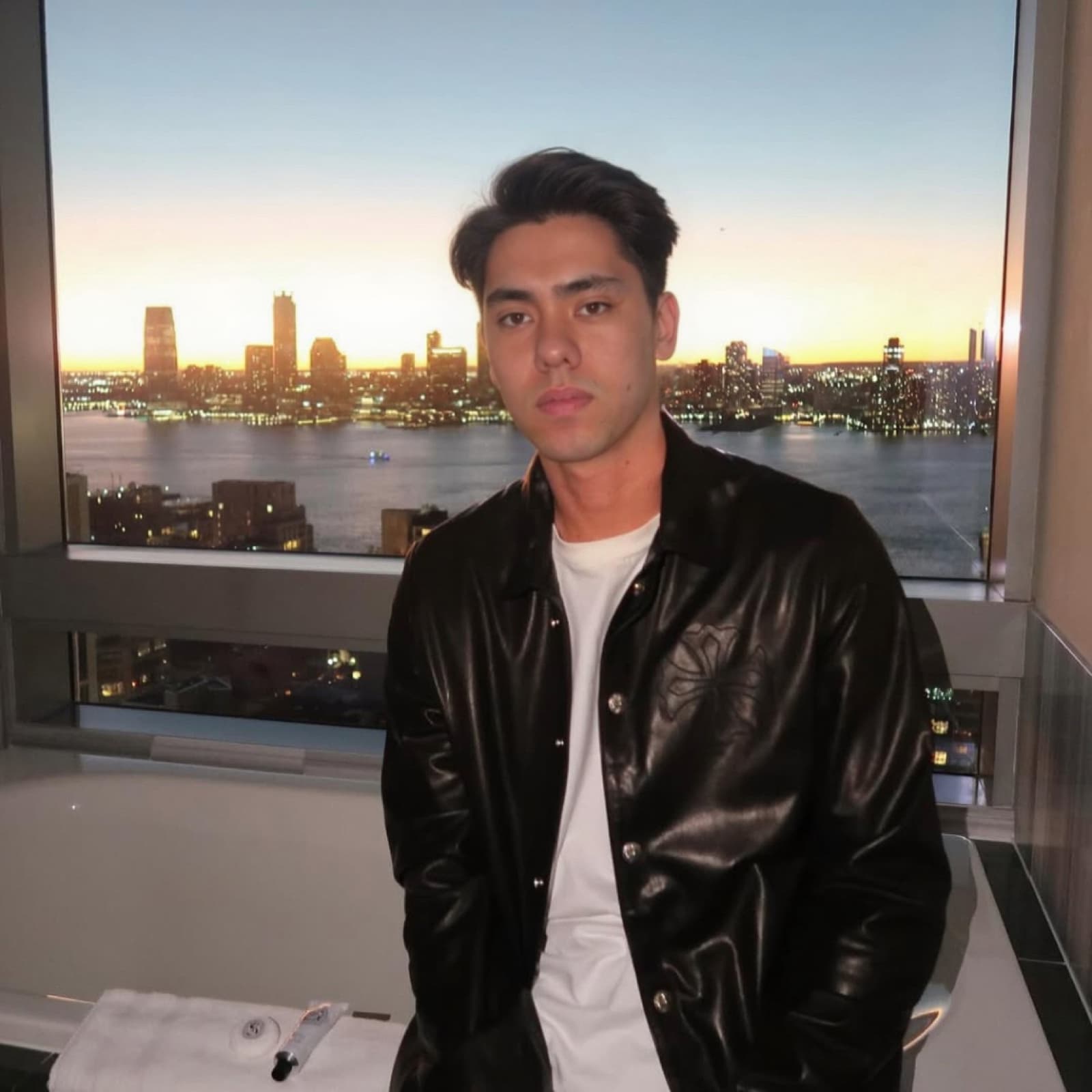 Matthew Stevens with a city skyline at sunset behind him.