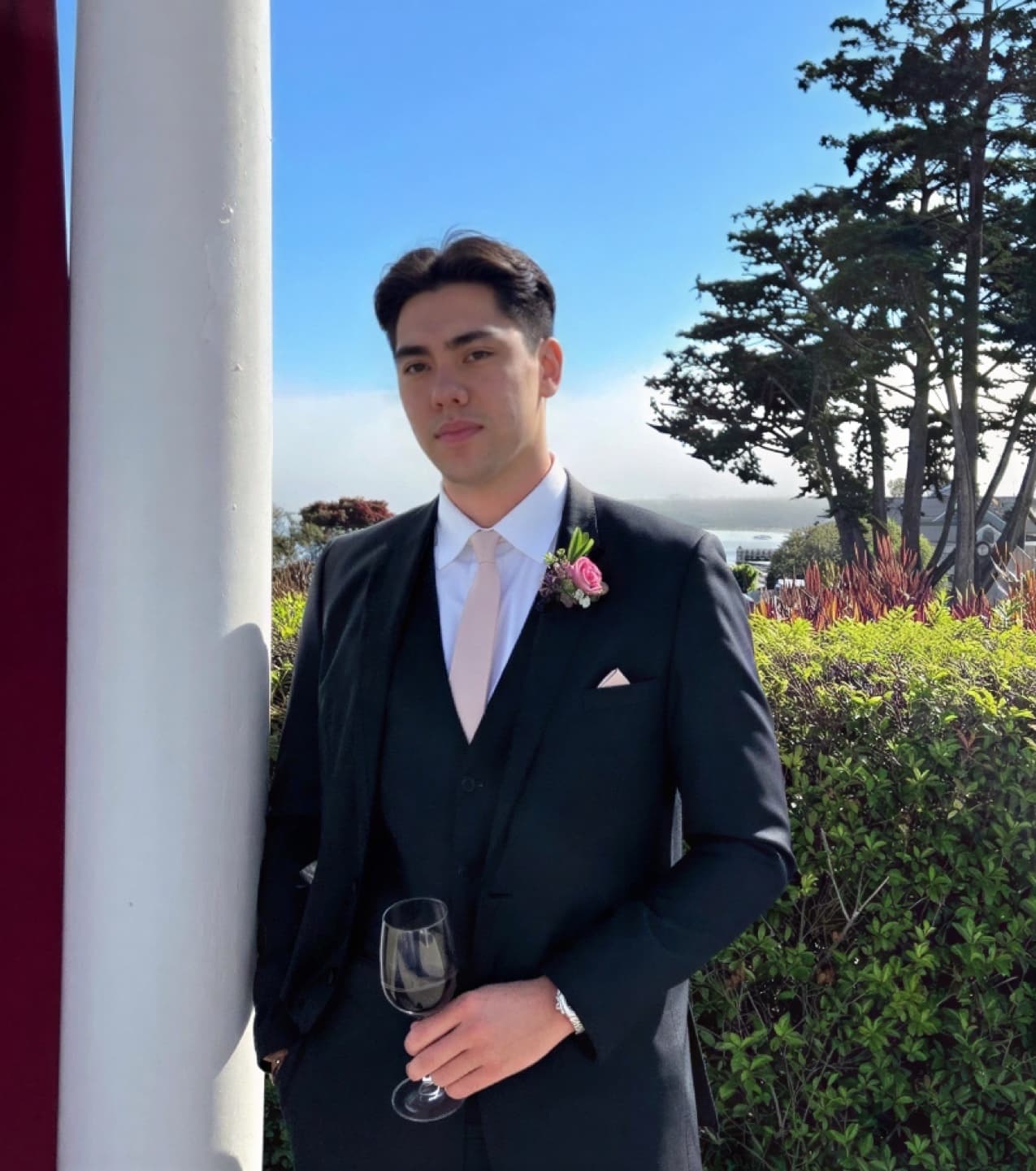 Matthew Stevens in a suit holding a glass.